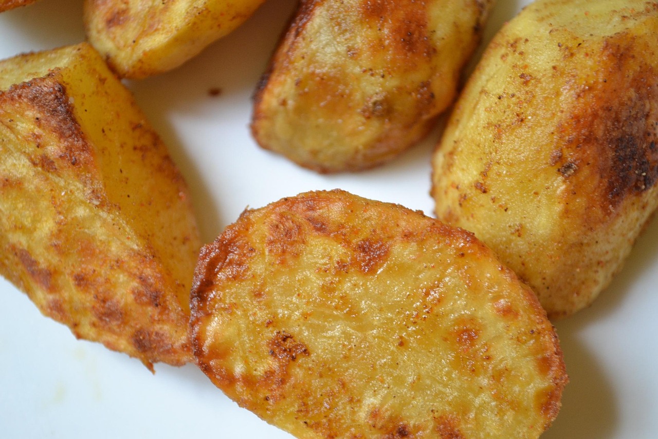 Patate a cubetti pronte per essere condite e cotte al forno, con una superficie dorata e croccante.