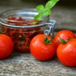 Pomodori freschi su un tagliere, pronti per la conservazione in cucina.