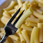 Pasta cotta al dente in un piatto, evidenziando la consistenza e il colore.