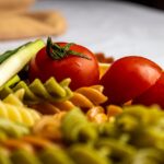 Pasta al pomodoro servita in un piatto, con ingredienti freschi e basilico decorativo.