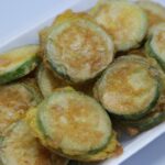 Zucchine dorate in padella, condite con spezie e erbe aromatiche, pronte da gustare.