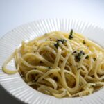 Pasta al limone con crema vellutata, decorata con scorza di limone fresco.
