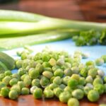 Piselli surgelati in un pentolino sul fuoco, pronti per essere cotti.